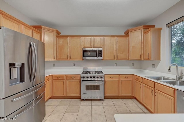 kitchen featuring appliances with stainless steel finishes, a sink, light brown cabinetry, and light countertops