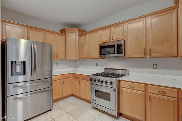kitchen with appliances with stainless steel finishes, light brown cabinetry, light tile patterned floors, and light countertops