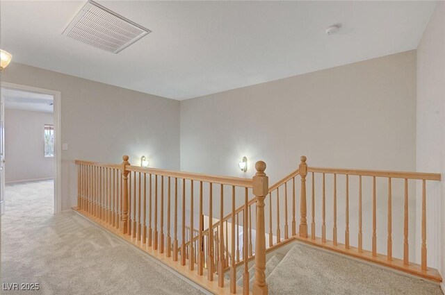 hall featuring an upstairs landing and carpet flooring