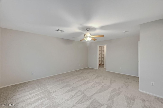 empty room with ceiling fan, light carpet, and baseboards