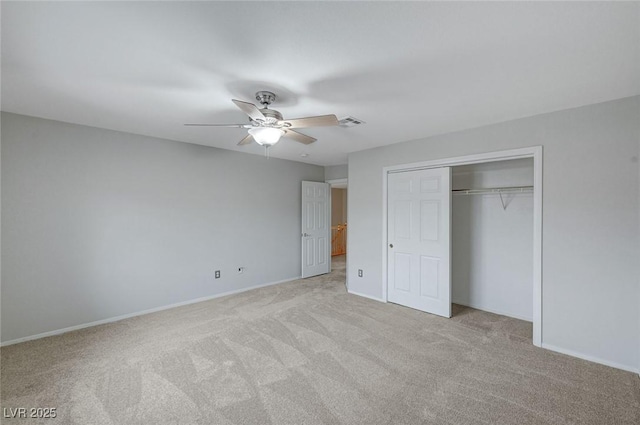 unfurnished bedroom featuring light colored carpet, a closet, baseboards, and ceiling fan