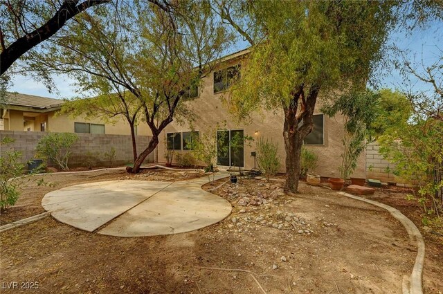 back of property with a patio, stucco siding, and fence