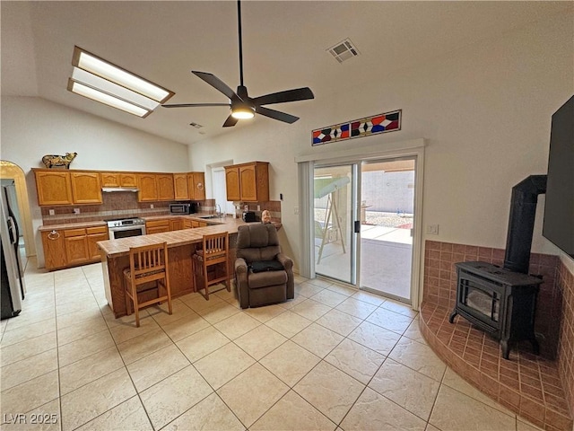 kitchen featuring a sink, a peninsula, stainless steel appliances, visible vents, and ceiling fan