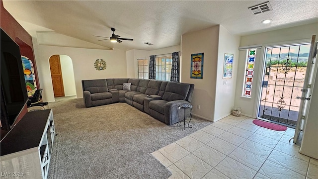 living area featuring a textured ceiling, carpet, arched walkways, and plenty of natural light