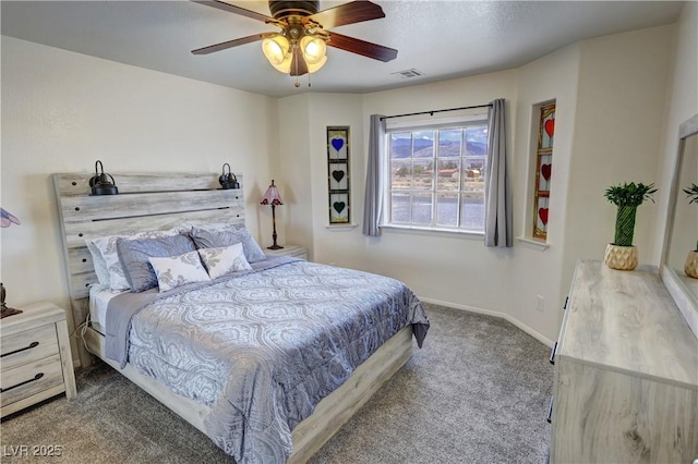 carpeted bedroom with visible vents, baseboards, and ceiling fan