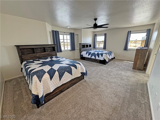 bedroom with multiple windows, a textured ceiling, and carpet floors