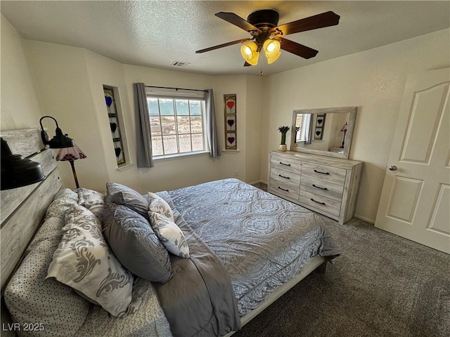 carpeted bedroom with a ceiling fan, visible vents, and a textured ceiling