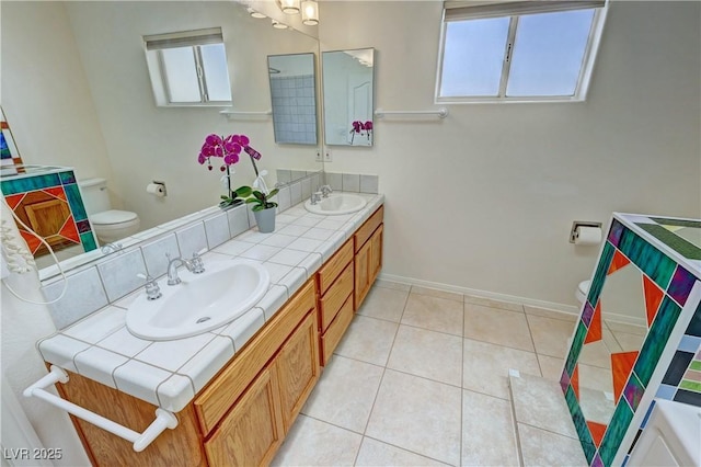 bathroom featuring toilet, plenty of natural light, and a sink