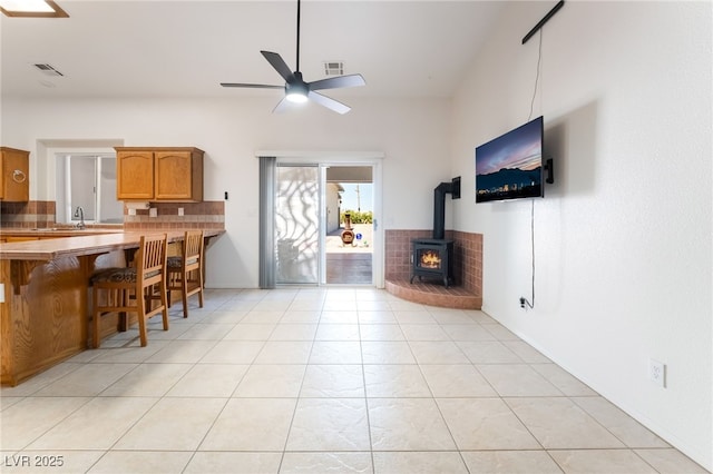 2650 Sagebrush Ave, Pahrump, NV 89048 - living area featuring a wood stove, ceiling fan, and light tile patterned flooring