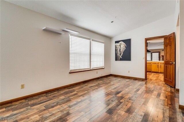5242 Dickens Dr, Las Vegas, NV 89119 - empty room featuring baseboards, hardwood / wood-style floors, and vaulted ceiling