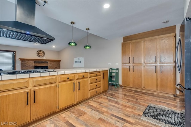 5242 Dickens Dr, Las Vegas, NV 89119 - kitchen with hanging light fixtures, freestanding refrigerator, range hood, light wood-type flooring, and vaulted ceiling