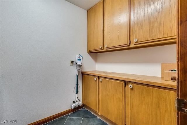 5242 Dickens Dr, Las Vegas, NV 89119 - laundry room featuring dark tile patterned flooring, a textured wall, and baseboards