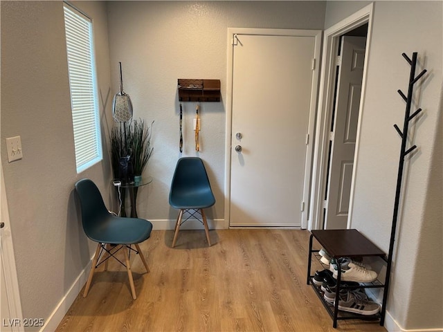 living area with baseboards and wood finished floors