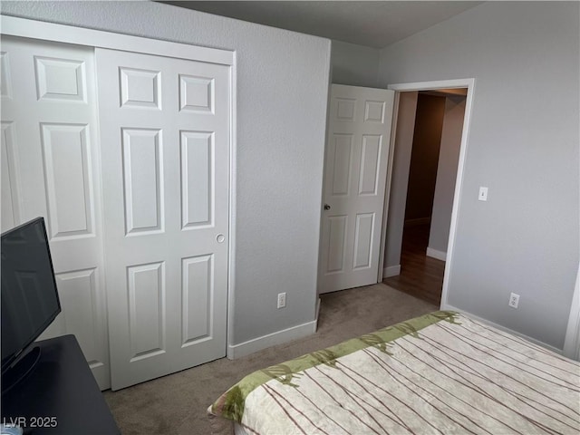 carpeted bedroom with a closet and baseboards