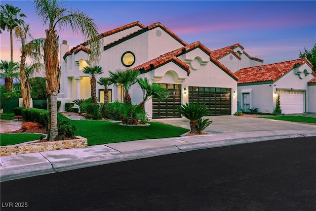 2589 Sun Reef Rd, Las Vegas, NV 89128 - mediterranean / spanish house with driveway, a tile roof, stucco siding, a garage, and a front lawn