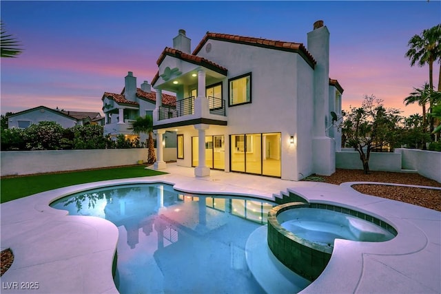 2589 Sun Reef Rd, Las Vegas, NV 89128 - rear view of house with a balcony, a chimney, a pool with connected hot tub, a patio area, and stucco siding