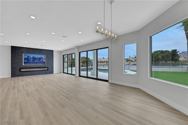 2589 Sun Reef Rd, Las Vegas, NV 89128 - unfurnished living room with a fireplace, light wood-style floors, and recessed lighting