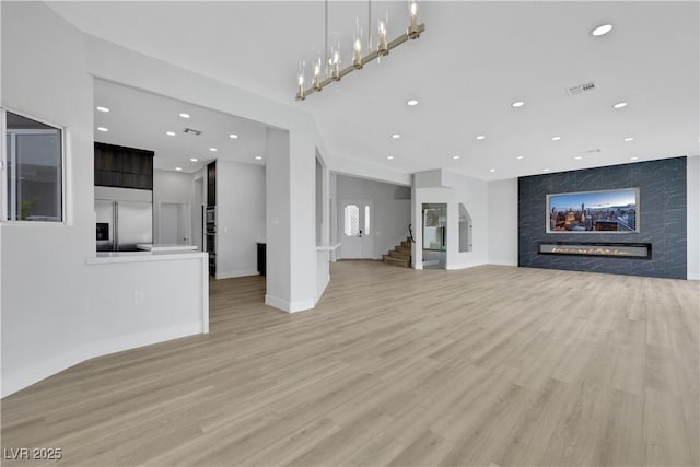 2589 Sun Reef Rd, Las Vegas, NV 89128 - unfurnished living room featuring a fireplace, recessed lighting, light wood-type flooring, and stairway