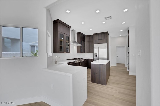 2589 Sun Reef Rd, Las Vegas, NV 89128 - kitchen with stainless steel appliances, wall chimney range hood, dark brown cabinets, light countertops, and modern cabinets