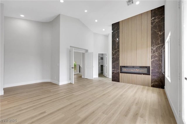 2589 Sun Reef Rd, Las Vegas, NV 89128 - unfurnished living room featuring high vaulted ceiling, a high end fireplace, wood finished floors, and recessed lighting