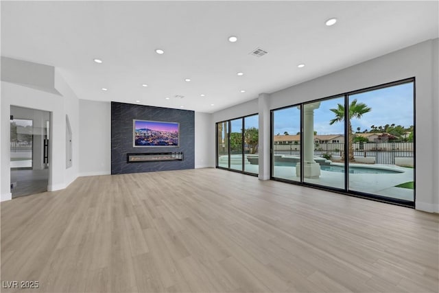 2589 Sun Reef Rd, Las Vegas, NV 89128 - unfurnished living room with a high end fireplace, recessed lighting, and light wood-type flooring