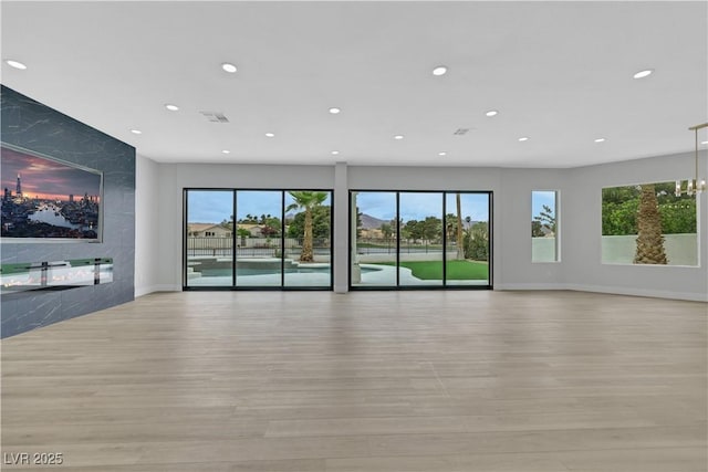 2589 Sun Reef Rd, Las Vegas, NV 89128 - unfurnished living room with recessed lighting, light wood-style flooring, and plenty of natural light