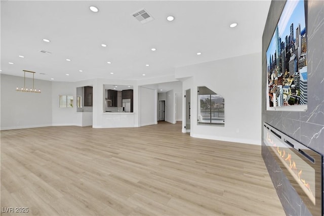 2589 Sun Reef Rd, Las Vegas, NV 89128 - unfurnished living room featuring recessed lighting, a fireplace, and light wood-type flooring