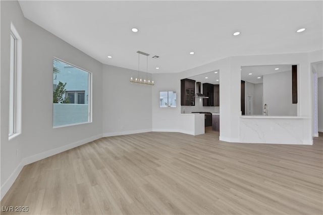 2589 Sun Reef Rd, Las Vegas, NV 89128 - unfurnished living room with light wood-style flooring, recessed lighting, and a chandelier
