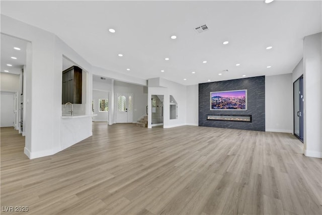 2589 Sun Reef Rd, Las Vegas, NV 89128 - unfurnished living room featuring a fireplace, light wood finished floors, and recessed lighting