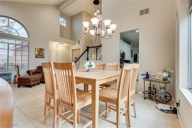 dining room with light tile patterned floors, high vaulted ceiling, visible vents, and an inviting chandelier