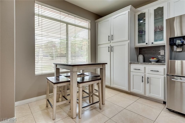 dining room featuring baseboards and light tile patterned flooring