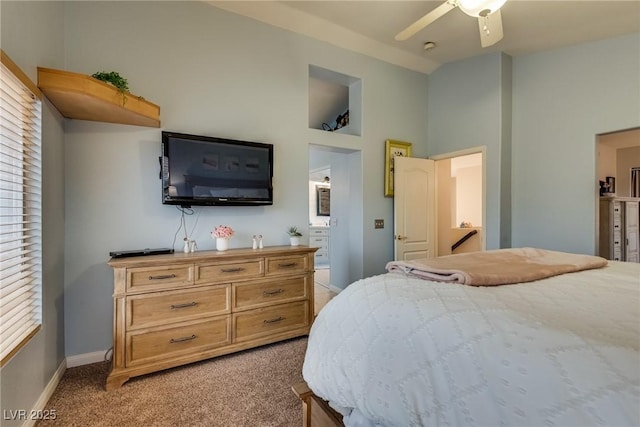 bedroom with vaulted ceiling, ceiling fan, light carpet, and baseboards