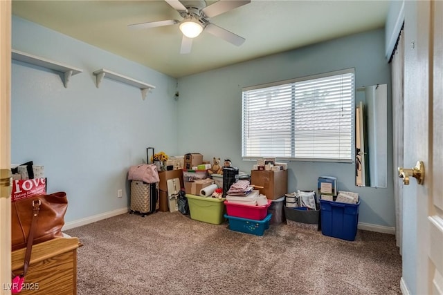 interior space with a ceiling fan, baseboards, and carpet floors