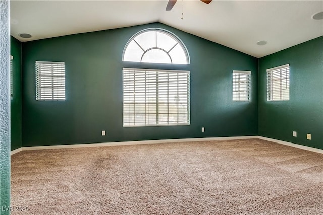 carpeted spare room with plenty of natural light, vaulted ceiling, baseboards, and ceiling fan