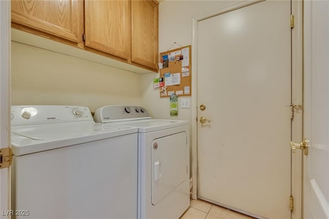 washroom featuring washing machine and clothes dryer, cabinet space, and light tile patterned floors