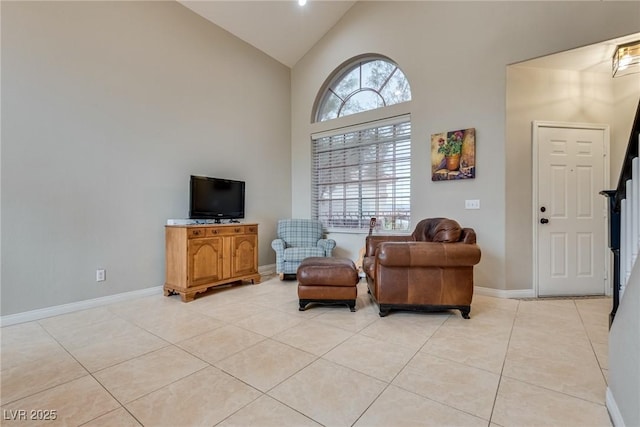 sitting room with baseboards, high vaulted ceiling, and light tile patterned flooring