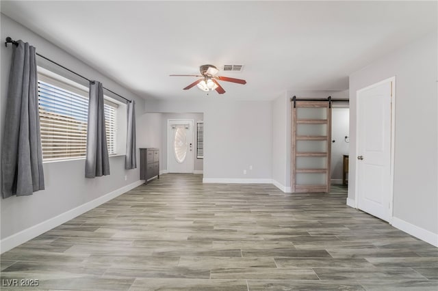 2046 Waverly Cir, Henderson, NV 89014 - unfurnished room with ceiling fan, a barn door, baseboards, and wood finished floors