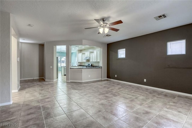 4124 Gliding Gulls Ave, North Las Vegas, NV 89084 - unfurnished living room featuring a ceiling fan, light tile patterned floors, baseboards, and a textured ceiling