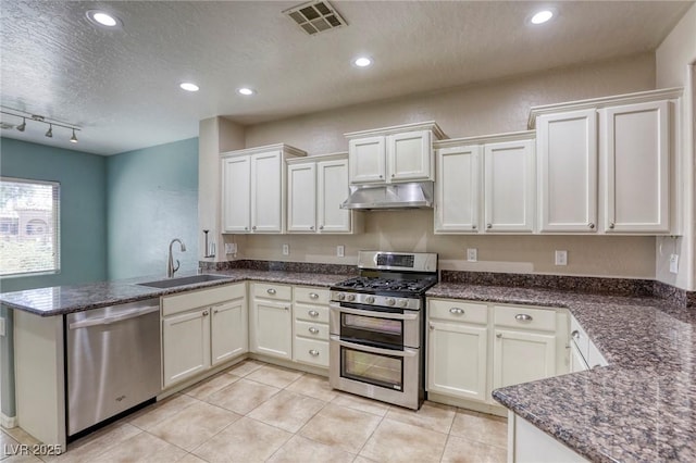 4124 Gliding Gulls Ave, North Las Vegas, NV 89084 - kitchen with stainless steel appliances, a sink, under cabinet range hood, a peninsula, and light tile patterned floors