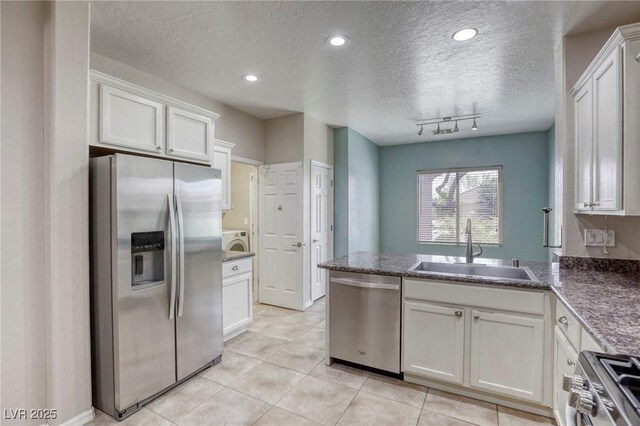 4124 Gliding Gulls Ave, North Las Vegas, NV 89084 - kitchen featuring appliances with stainless steel finishes, a sink, light tile patterned flooring, a textured ceiling, and a peninsula