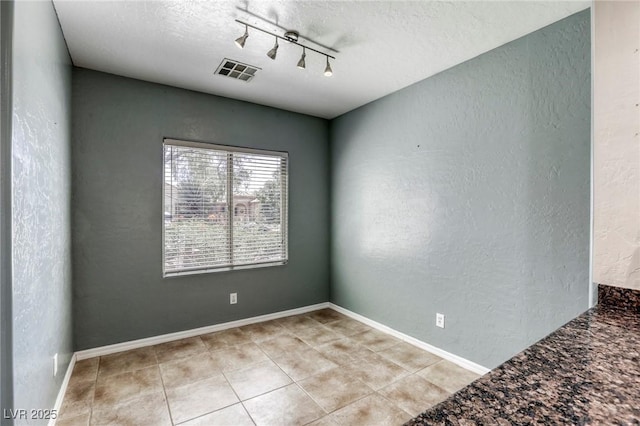 4124 Gliding Gulls Ave, North Las Vegas, NV 89084 - spare room featuring track lighting, light tile patterned floors, a textured ceiling, a textured wall, and baseboards
