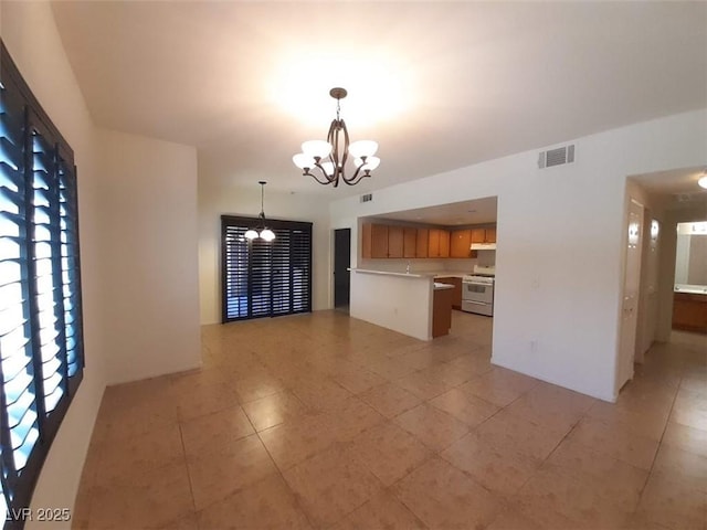 9580 W Reno Ave Unit 183, Las Vegas, NV 89148 - interior space featuring a notable chandelier, light countertops, brown cabinetry, visible vents, and white range with gas cooktop