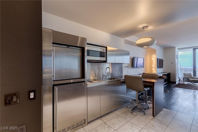 4381 W Flamingo Rd Unit 3818, Las Vegas, NV 89103 - kitchen with stainless steel appliances, a kitchen breakfast bar, pendant lighting, stainless steel counters, and modern cabinets