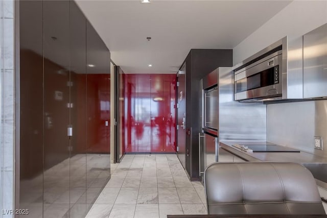 4381 W Flamingo Rd Unit 3818, Las Vegas, NV 89103 - kitchen with marble finish floor, black electric cooktop, modern cabinets, and stainless steel microwave
