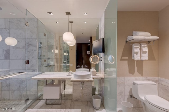 4381 W Flamingo Rd Unit 3818, Las Vegas, NV 89103 - full bath with a stall shower, tile walls, toilet, a sink, and tile patterned flooring