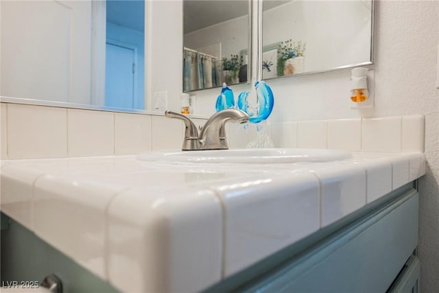 interior details with vanity and a textured wall