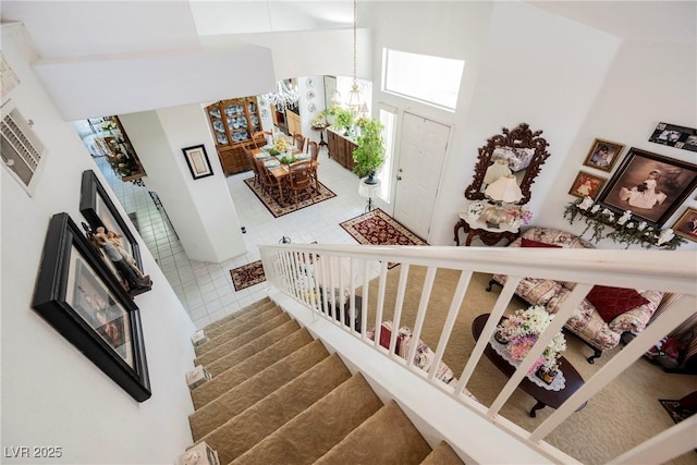 stairway with a chandelier and a high ceiling
