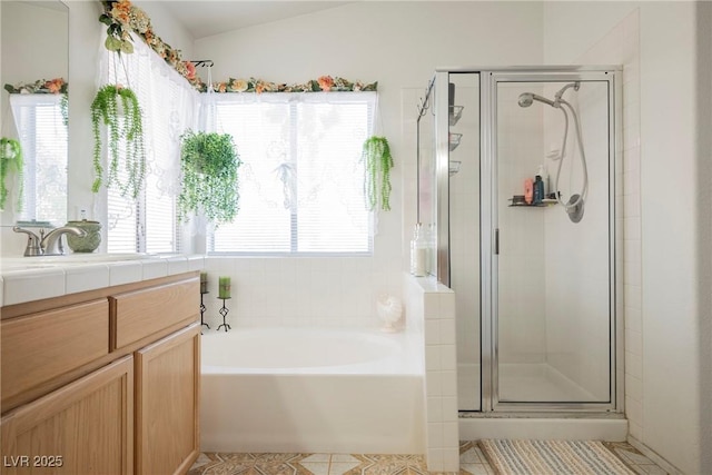 full bathroom with a stall shower, a bath, tile patterned flooring, lofted ceiling, and vanity