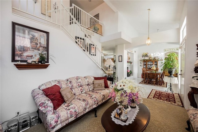 living room featuring carpet floors, stairway, and a towering ceiling