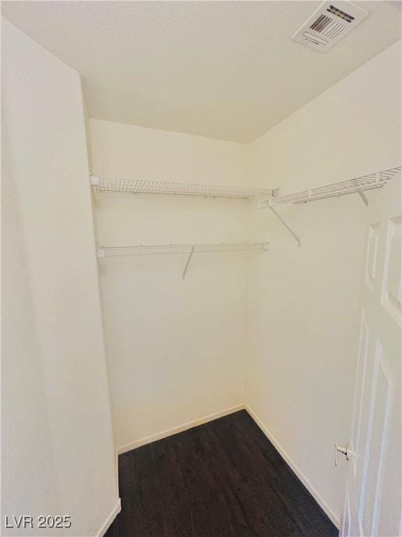 walk in closet featuring dark wood-type flooring